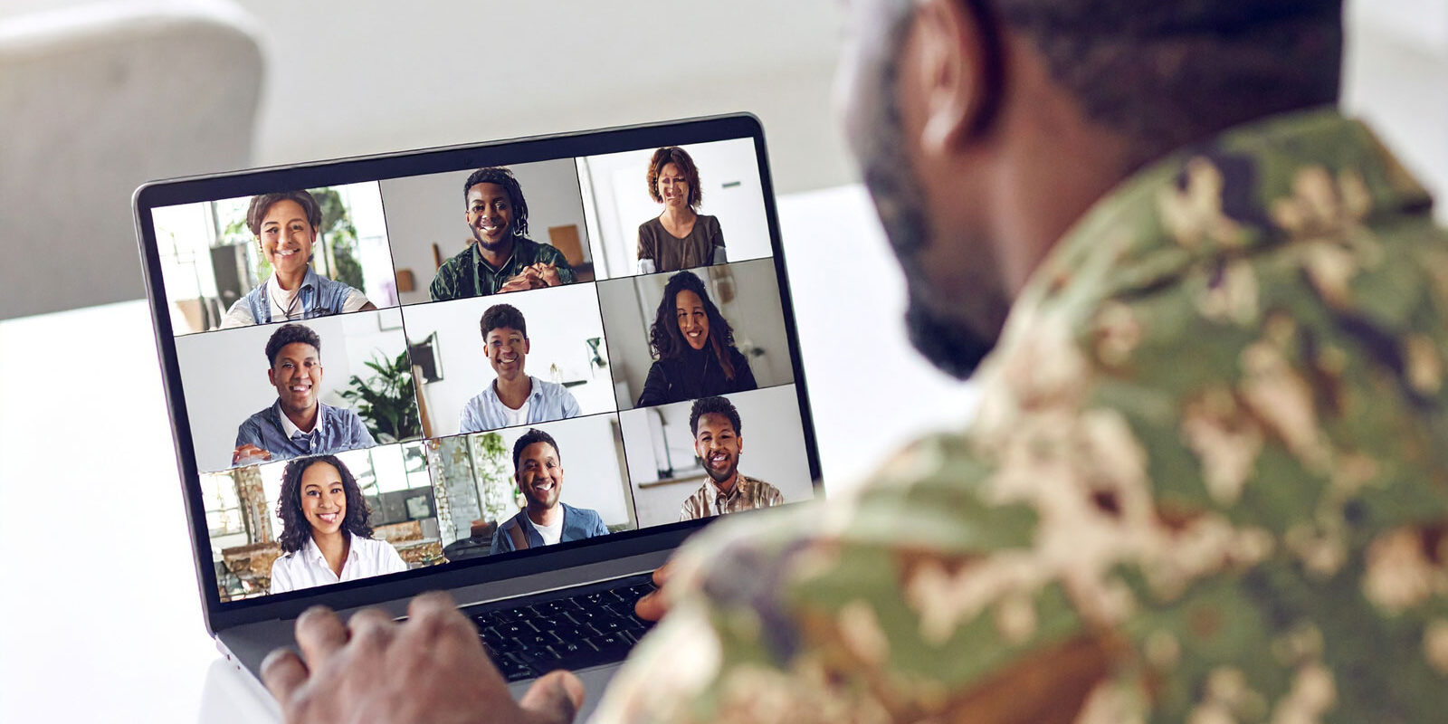 man-on-military-uniform-looking-at-a-laptop-screen-that-shows-a-grid man-on-military-uniform-looking-at-a-laptop-screen-that-shows-a-grid